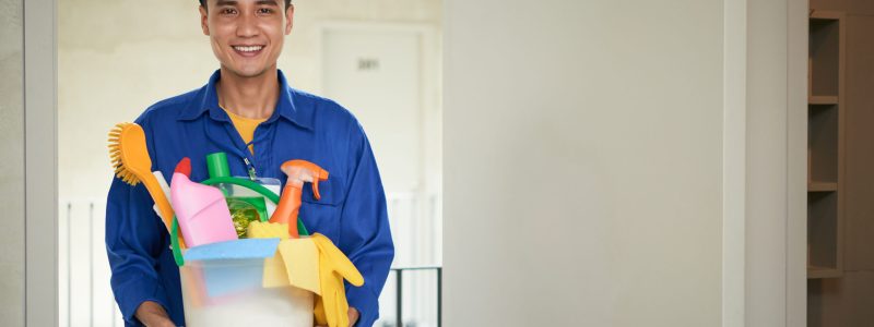Portrait of young Asian cleaning manager with bucket of cleaning supplies